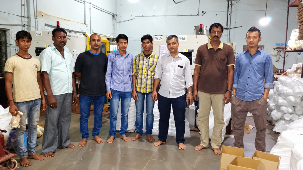 Krishna Polymer Technology team standing in front of injection moulding machines at the Jeedimetla plant