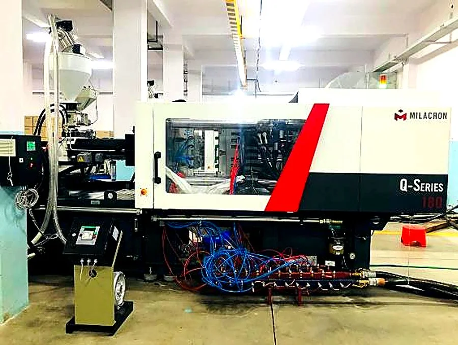 Multiple Milacron injection moulding machines with raw material on the production floor