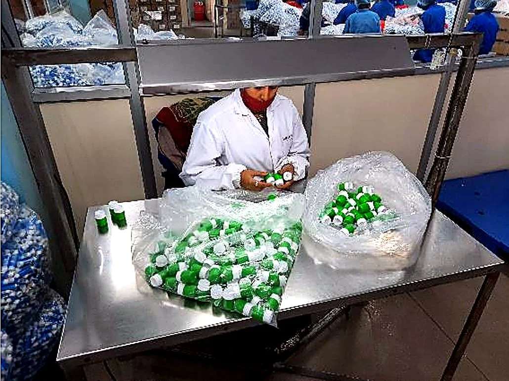 Moulded caps being inspected and packed by hand